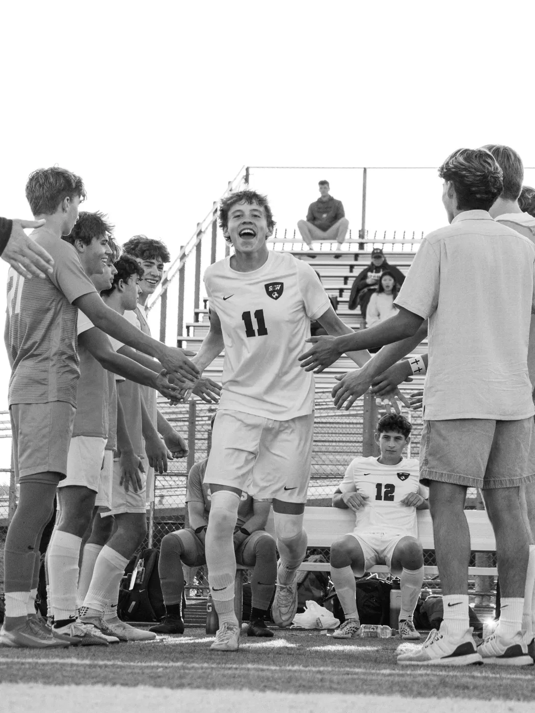 Soccer player running through a tunnel formed by his teammates