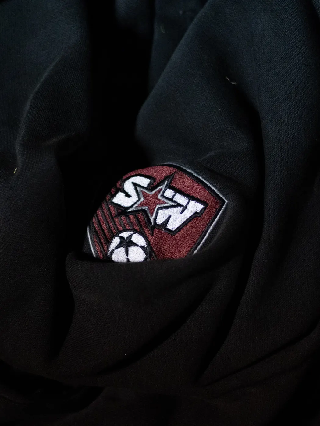 Close-up of an SWCHS soccer crest on a black equipment bag