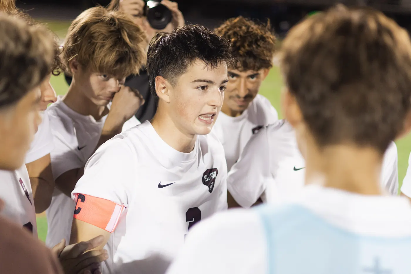 Soccer captain speaking inside a tight team huddle